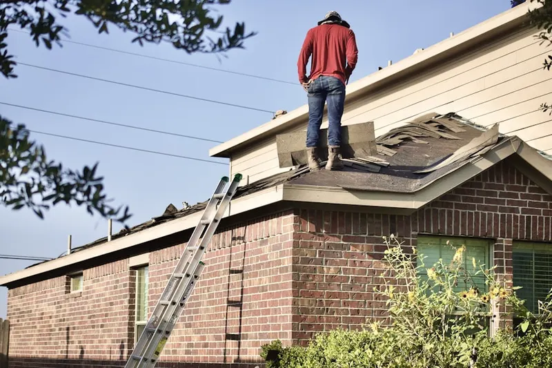 Professional roofer working on a residential roof in Herricks
